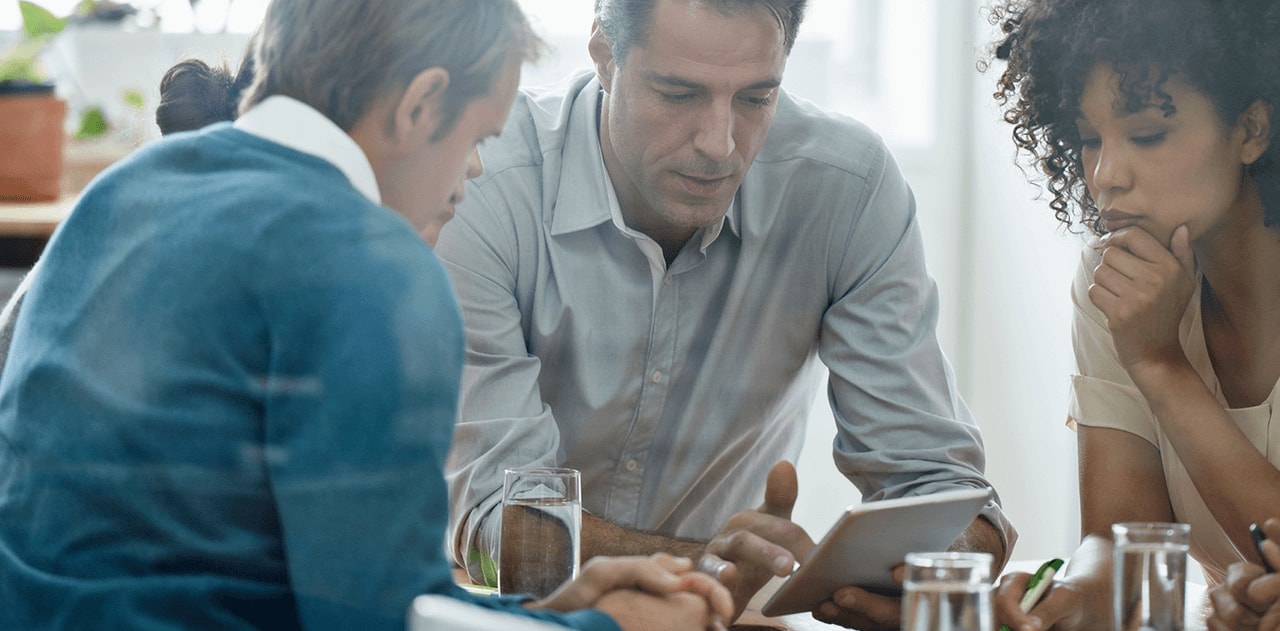 Team of people looking over an iPad